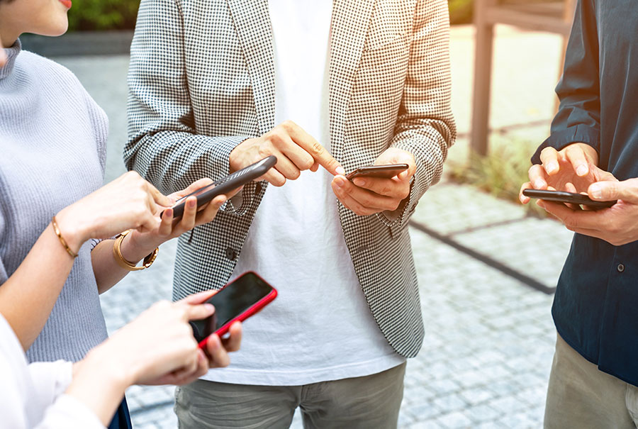 スマホを手に取る人々